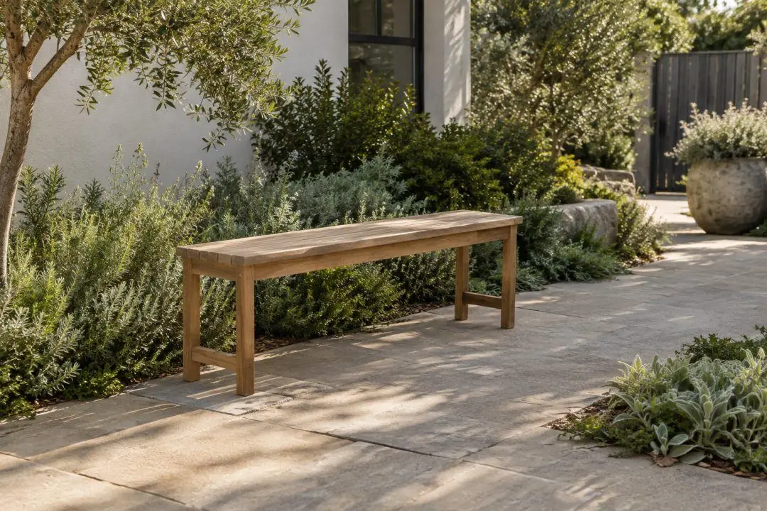 A simple outdoor bench on a level paved garden area.