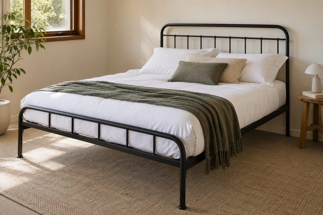 A black metal bed frame with white bedding in a simple bedroom.